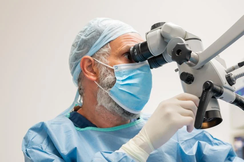 Surgeon at an operating microscope during a procedure