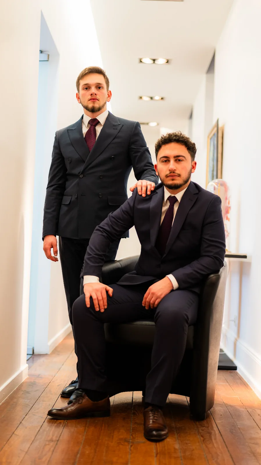 Portrait de deux associés, l'un assis, l'autre debout derrière lui
